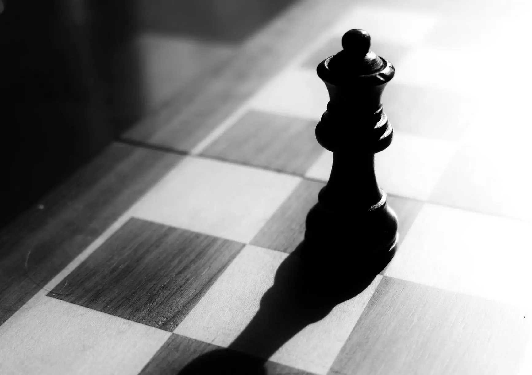 black chess piece on brown and white checkered table